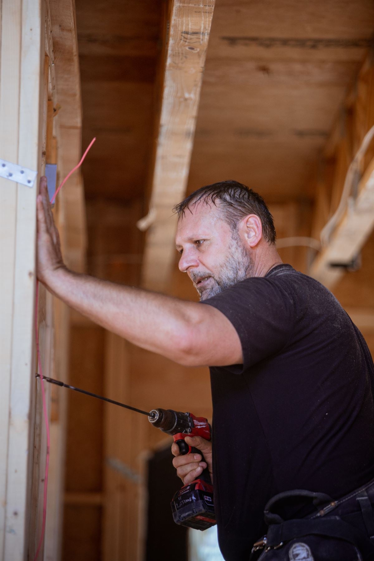 Secur-Tek technician drilling framing for a cable run